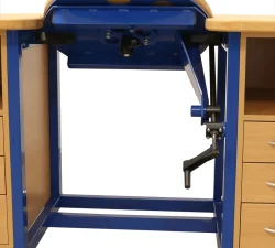 Unter der Werkbank zeigen sich der blaue Stahlrahmen, der Feststellhebel und die Kippmechanik zwischen den Holzseiten und dem Arbeitstisch.