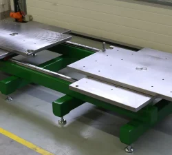 Der Werkzeugöffner KFM zeigt zwei verschiebbare Metallplatten auf grünem Trägerrahmen für das sichere Öffnen von Spritzgussformen.