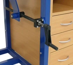 Ein blauer Stahlrahmen trägt den Kippmechanismus einer Werkbank neben einem Holzschubladenschrank mit Metallgriffen für den Werkzeugbau.