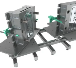 Zwei METPAC Spritzgussformen stehen auf einer Metallkonstruktion mit Gewindespindeln und grünen Spannhebeln.