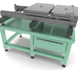 Auf dem mintgrünen Werktisch steht eine graue Präzisions-Spannvorrichtung mit verstellbaren Platten und robusten Stützfüßen für die Werkstückaufnahme.