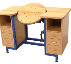 Massive Werkbank mit drehbarer, kippbarer Mittelplatte, zwei Seitenschränken, drei Schubladen pro Seite und blauer Stahlkonstruktion auf weißem Grund.